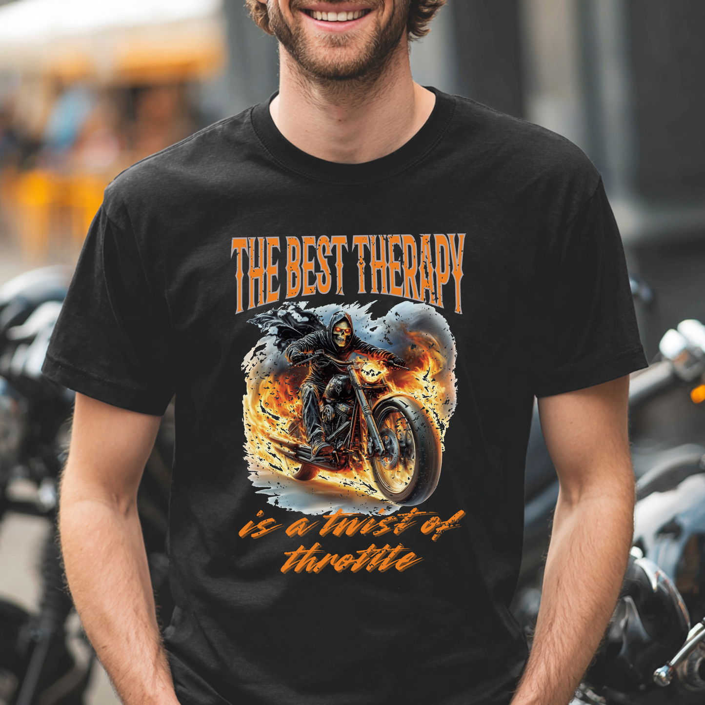 Man wearing a black t-shirt with a graphic design and text, standing in front of motorcycles.