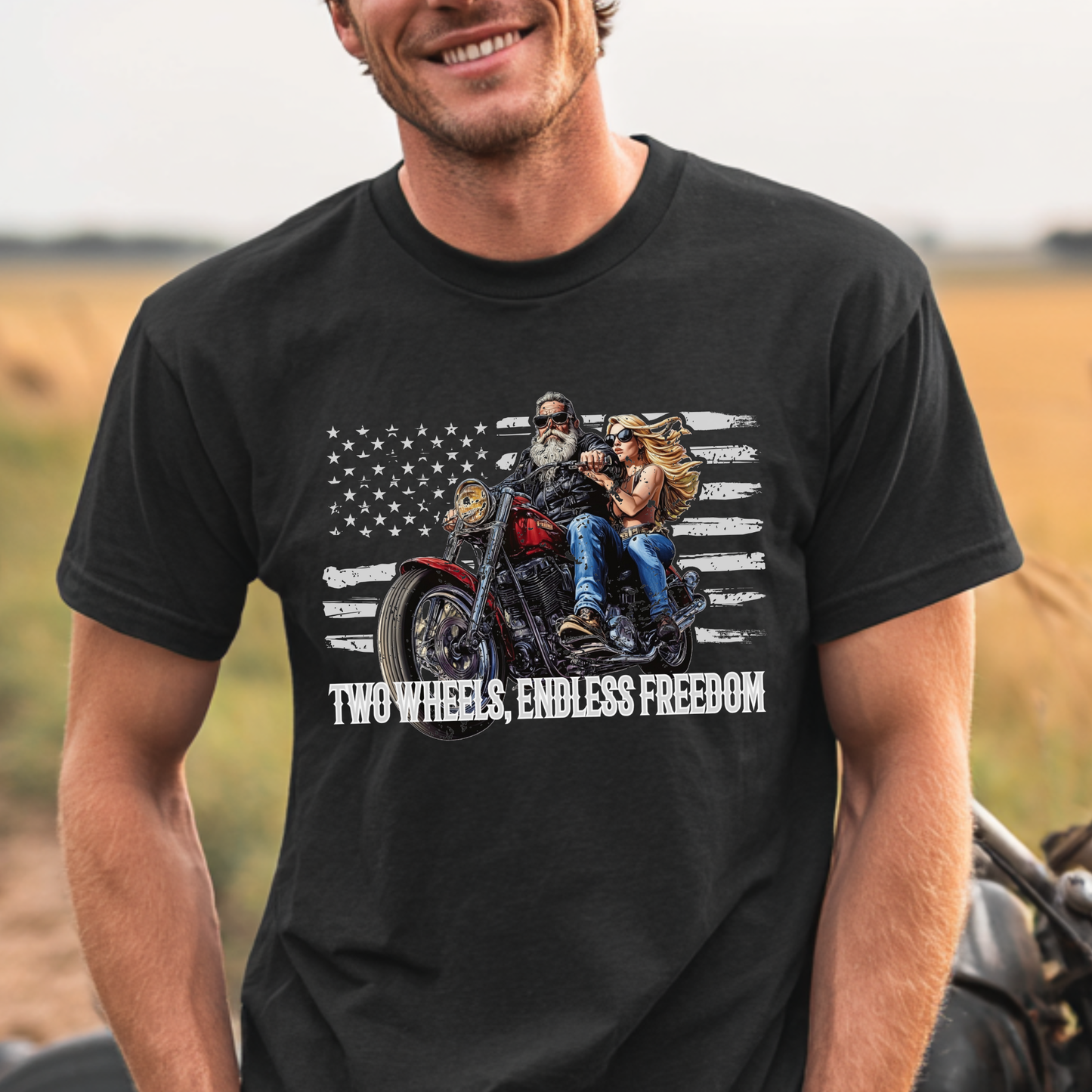 Man wearing a black t-shirt with a graphic of two people on a motorcycle and 'Two Wheels, Endless Freedom' text.