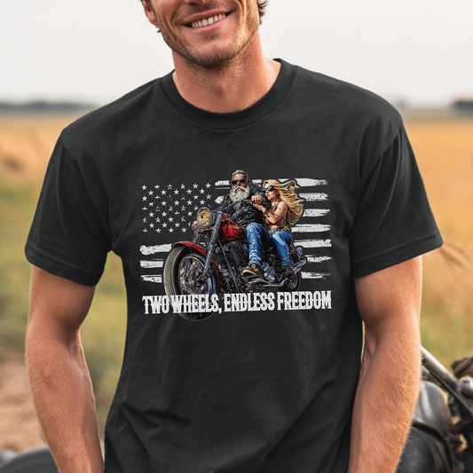 Man wearing a black t-shirt with a graphic of two people on a motorcycle and 'Two Wheels, Endless Freedom' text.