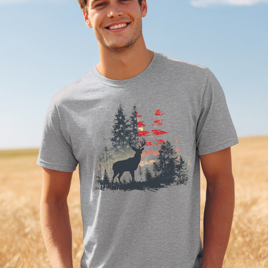 Man wearing a gray t-shirt with a deer graphic in a field