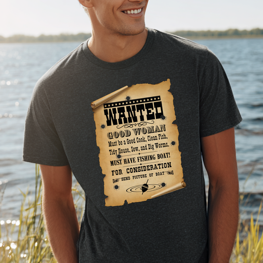 Person wearing a t-shirt with a 'Wanted' poster design by a lake