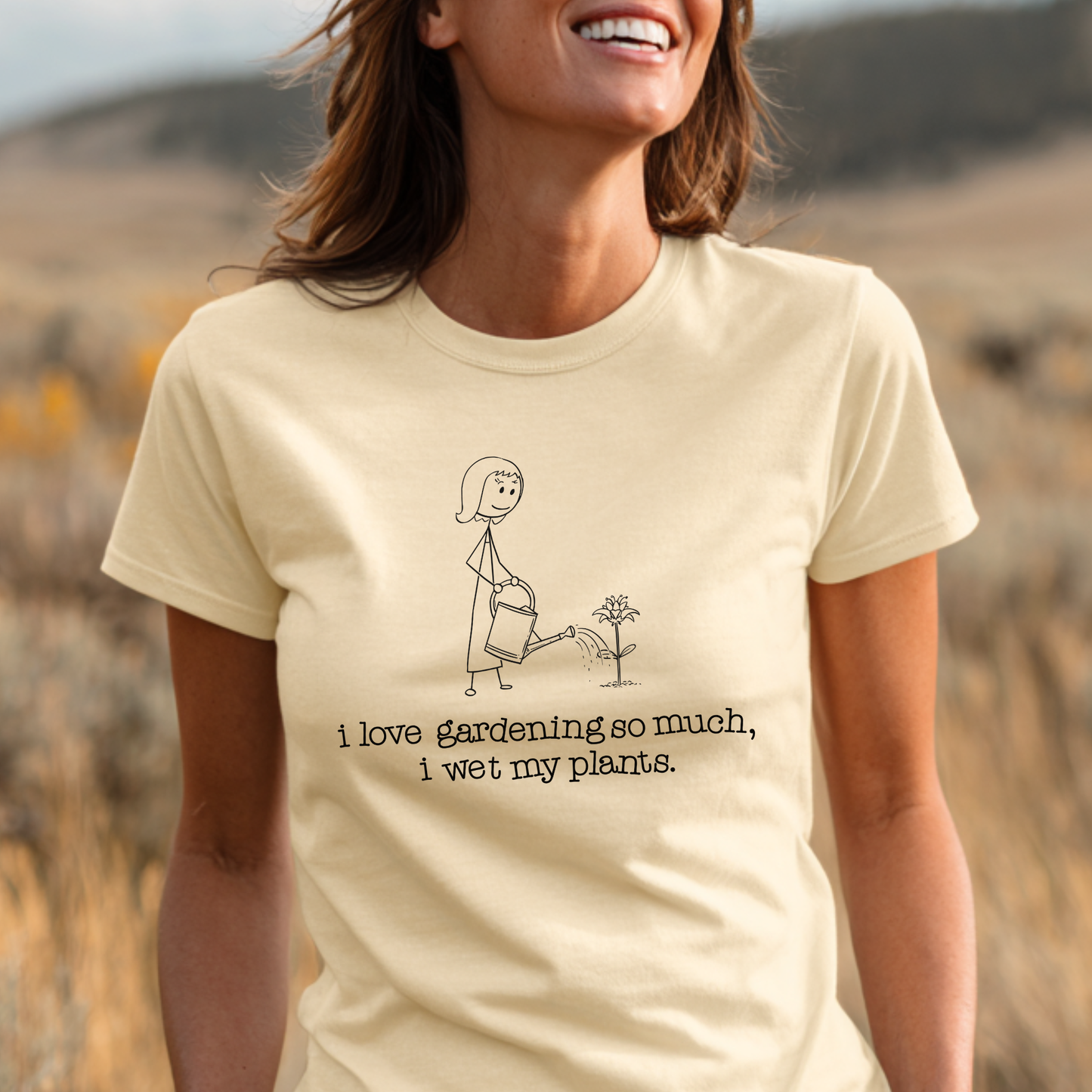 Person wearing a beige t-shirt with a gardening graphic and text in a desert setting