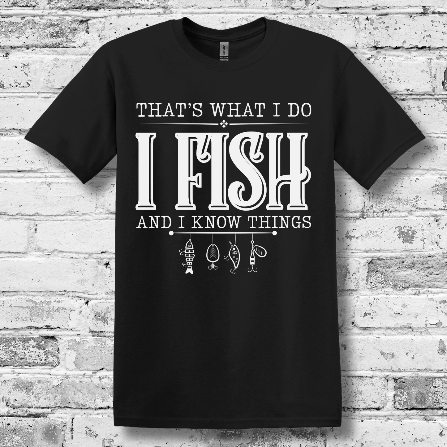 Black t-shirt with white text and fishing-related graphics on a brick wall background