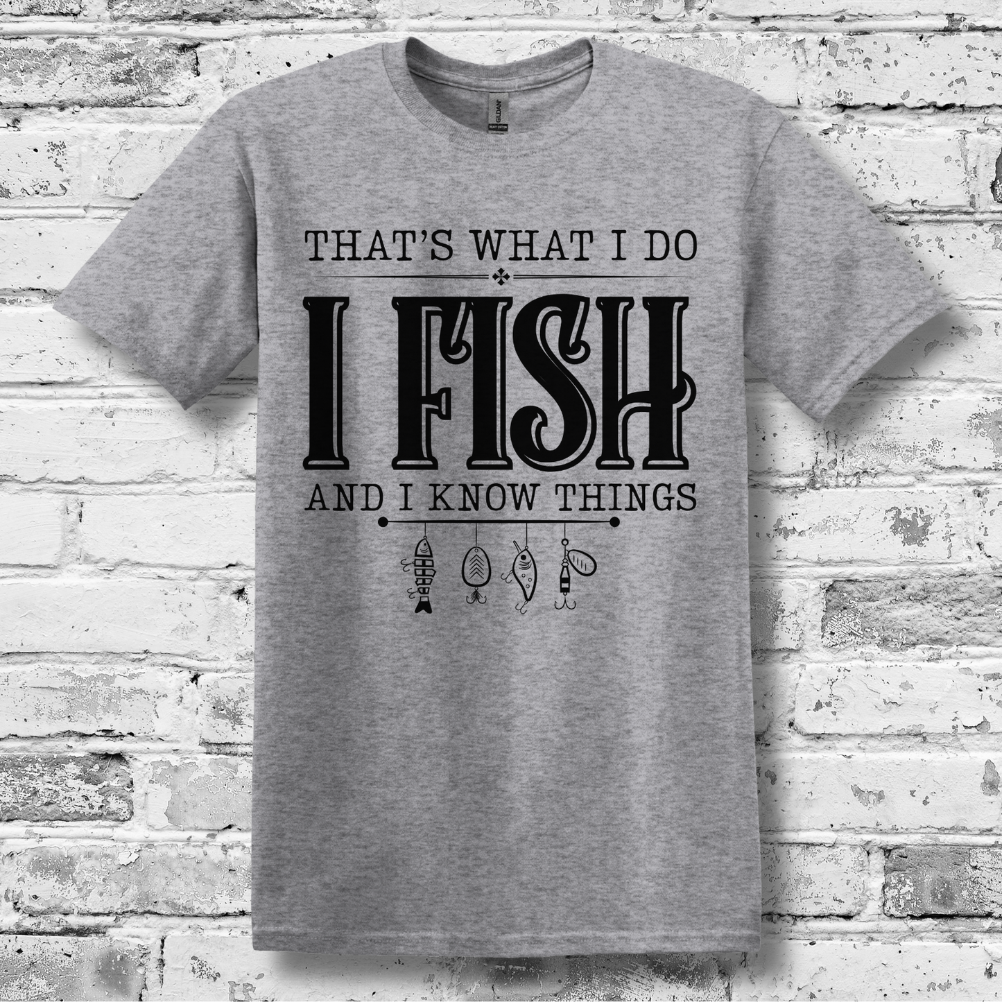 Gray t-shirt with text 'I Fish and I Know Things' on a brick wall background