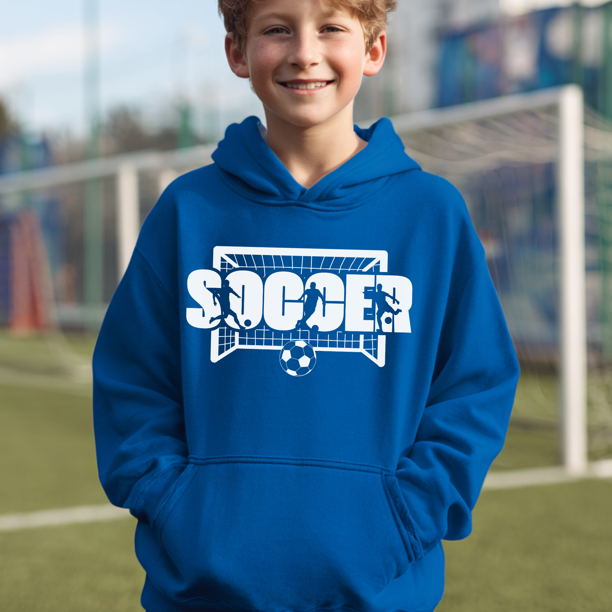 Child wearing a blue hoodie with a soccer graphic on a sports field