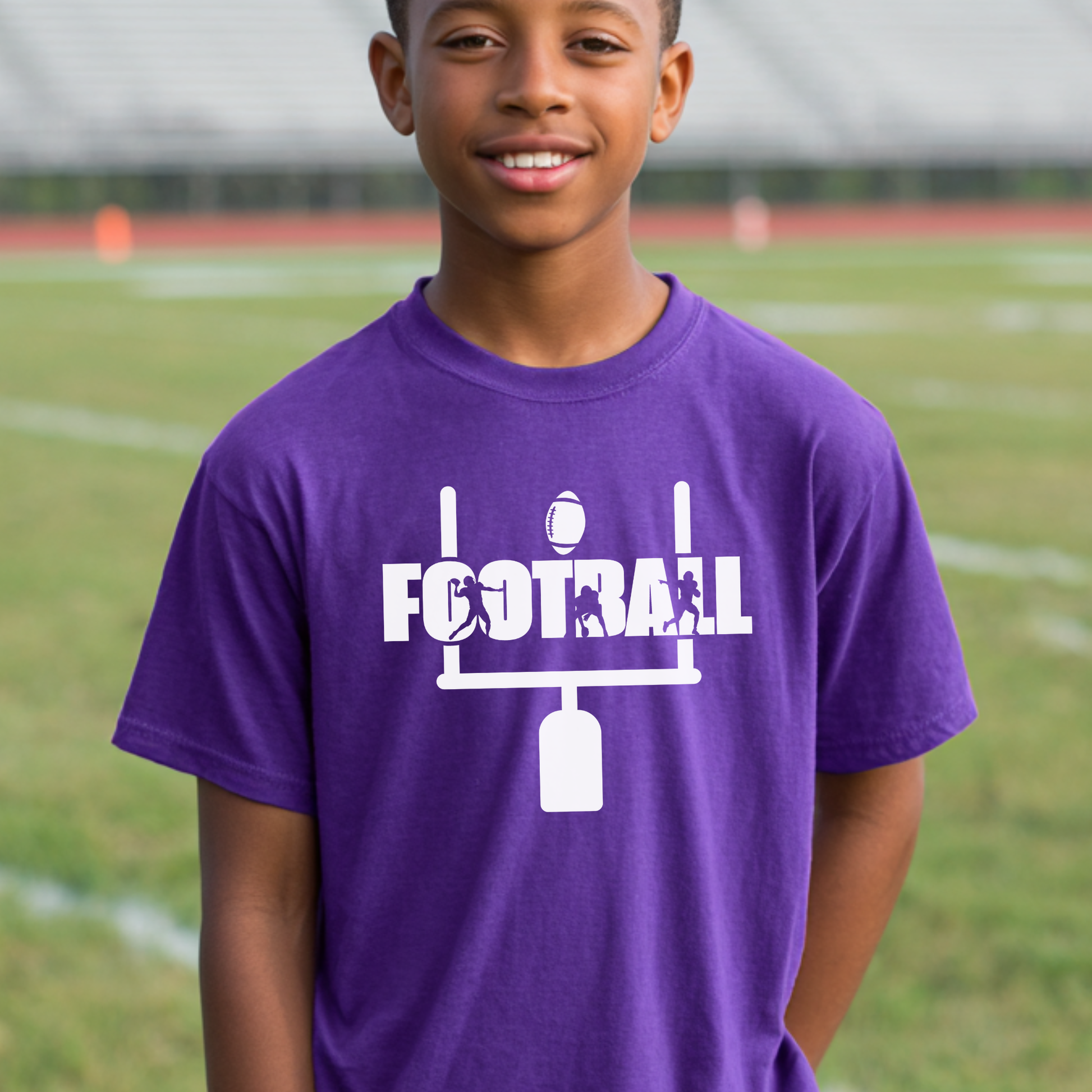 Child wearing a purple t-shirt with 'FOOTBALL' design on a sports field background