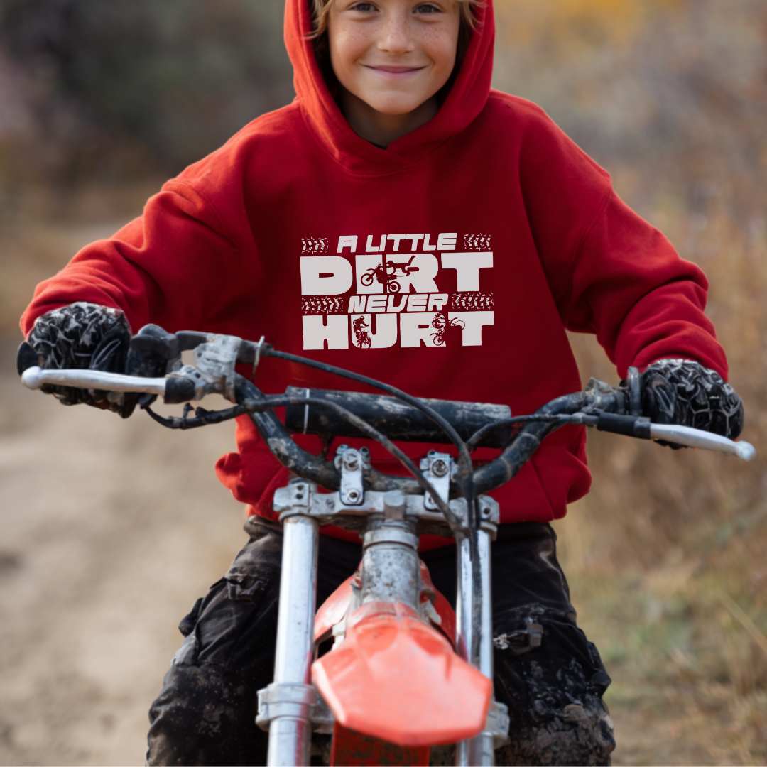 Child wearing a red hoodie with text on a dirt bike in an outdoor setting