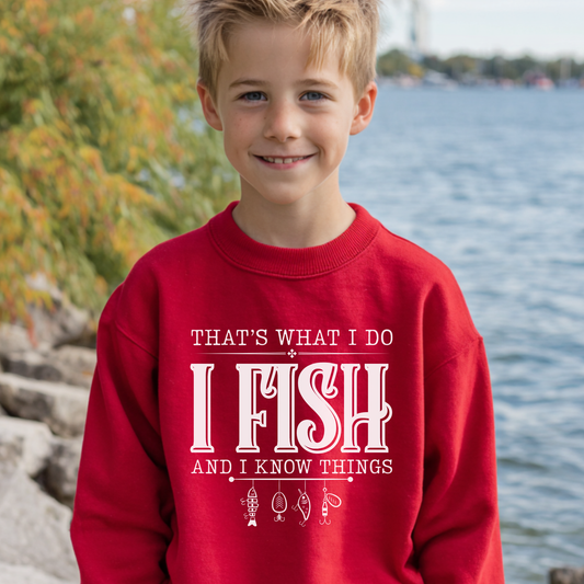 Child wearing a red sweatshirt with text by a body of water