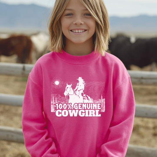 Child wearing a pink sweatshirt with a cowgirl design and text, standing in front of horses.